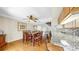 Inviting dining room features wood floors, ceiling fan, a large table with seating for eight and a view into the kitchen at 443 Pinellas Bayway S # 105, Tierra Verde, FL 33715