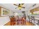The dining room features wood floors, ceiling fan, art and access to the kitchen with granite countertops at 443 Pinellas Bayway S # 105, Tierra Verde, FL 33715