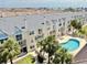 Beautiful condo exterior featuring a shared pool, balconies, and tropical landscaping at 443 Pinellas Bayway S # 105, Tierra Verde, FL 33715