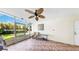 Relaxing screened lanai with tile flooring, ceiling fan, and view of landscaped backyard at 443 Pinellas Bayway S # 105, Tierra Verde, FL 33715