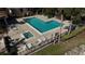 Aerial view of the community pool and spa, surrounded by lush landscaping, lounge chairs, and a clubhouse at 764 Captiva Ne Ct, St Petersburg, FL 33702