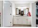 Bright bathroom featuring double mirrors above the vanity, white cabinets, and a tiled floor at 764 Captiva Ne Ct, St Petersburg, FL 33702