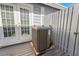 Exterior view of the home's HVAC unit, situated on a wooden deck next to double doors at 764 Captiva Ne Ct, St Petersburg, FL 33702