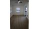 Bright living room with a modern ceiling fan, a light-toned floor, and view to the kitchen at 7932 Palatine Dr, Hudson, FL 34667