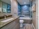 Modern bathroom featuring stylish blue tiled shower with a glass door and granite vanity at 8565 W Gulf Blvd # 17S, Treasure Island, FL 33706
