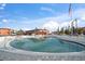 Community pool area with thatched umbrellas, lounge chairs, and the building in the background at 8565 W Gulf Blvd # 17S, Treasure Island, FL 33706