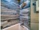 Close-up of a stylish blue tiled shower with a glass door and modern fixtures at 8565 W Gulf Blvd # 17S, Treasure Island, FL 33706