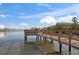 Waterfront view of a wooden pier perfect for relaxing or fishing by the calm waters at 8565 W Gulf Blvd # 17S, Treasure Island, FL 33706