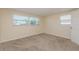 Cozy bedroom featuring plush carpeting, and ample natural light from large windows at 10118 Hickory Hill, Port Richey, FL 34668