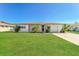 Charming single-story home with lush green lawn and mature landscaping under a clear blue sky at 10118 Hickory Hill, Port Richey, FL 34668