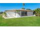 Well-maintained, single-story home featuring a lush green lawn, a well-kept exterior, and a blue sky at 10118 Hickory Hill, Port Richey, FL 34668
