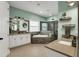 Elegant bathroom featuring dual vanities, a soaking tub, a glass shower, and stylish decor at 14214 Quintessa Ln, Lithia, FL 33547