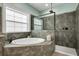 Luxurious bathroom with a soaking tub, walk-in shower, sleek fixtures, and ample natural light at 14214 Quintessa Ln, Lithia, FL 33547