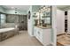 Modern bathroom with a soaking tub, walk-in shower, dual vanities, and ample storage space at 14214 Quintessa Ln, Lithia, FL 33547