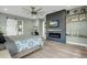 Stylish bedroom with a modern fireplace, mounted TV, barn door entrance, and sleek, contemporary design at 14214 Quintessa Ln, Lithia, FL 33547