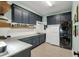 Well-organized laundry room featuring dark cabinetry, modern appliances, and plenty of counter space at 14214 Quintessa Ln, Lithia, FL 33547
