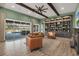 Cozy living room with hardwood floors, exposed beams, leather furniture, a large window, and open floor plan at 14214 Quintessa Ln, Lithia, FL 33547