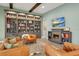 Cozy living room features a fireplace, a built-in bookcase, and leather armchairs for relaxing and entertaining at 14214 Quintessa Ln, Lithia, FL 33547