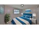 Cozy bedroom showcasing a plush blue bed with decorative pillows and stylish side tables at 6025 Florida S Cir, Apollo Beach, FL 33572