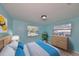 Inviting bedroom with bright blue walls, natural wood dresser, and comfortable bed at 6025 Florida S Cir, Apollo Beach, FL 33572