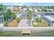 Aerial view of backyard with a patio, fire pit, mature palm trees, and canal access with a dock at 8722 Elmwood Ln, Tampa, FL 33615