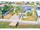 Aerial view of backyard featuring a patio, fire pit, mature palm trees, and canal access with a dock at 8722 Elmwood Ln, Tampa, FL 33615