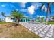 Spacious backyard with a modern patio, fire pit area, tropical palm trees, and a sunroom overlooking the yard at 8722 Elmwood Ln, Tampa, FL 33615