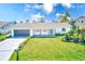 Charming single-story home featuring a well-manicured lawn, attached garage, and inviting front porch at 8722 Elmwood Ln, Tampa, FL 33615