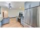 Open kitchen featuring stainless steel refrigerator, gray cabinets, and wood flooring throughout at 8722 Elmwood Ln, Tampa, FL 33615