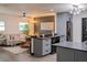 Open kitchen featuring stainless steel appliances, gray cabinets, and seamless transition to living room at 8722 Elmwood Ln, Tampa, FL 33615