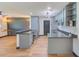 Open-concept kitchen with gray cabinetry, stainless steel appliances, and a view into the living area at 8722 Elmwood Ln, Tampa, FL 33615