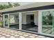 View through sliding doors, showing living space with geometric tile floors and modern furniture at 8722 Elmwood Ln, Tampa, FL 33615
