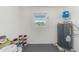 Utility room with a window, water heater, and space for storage or other appliances at 8722 Elmwood Ln, Tampa, FL 33615