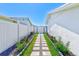 Charming side yard walkway with stepping stones, lush landscaping, and privacy fencing creating a tranquil entrance at 8722 Elmwood Ln, Tampa, FL 33615