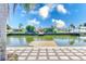 Picturesque waterfront scene showing a private dock extending into the canal, surrounded by lush landscaping at 8722 Elmwood Ln, Tampa, FL 33615