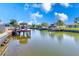 Scenic waterfront view featuring private docks and boat lifts against a backdrop of blue skies and lush greenery at 8722 Elmwood Ln, Tampa, FL 33615