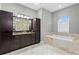 Spacious bathroom with dark wood cabinets, marble countertops, and a separate soaking tub at 1903 Haven Bend, Tampa, FL 33613