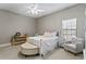 Bright bedroom with large window, chair, and area for desk, neutral walls, ceiling fan, and ottoman at 1903 Haven Bend, Tampa, FL 33613