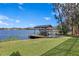 Lakeside boat dock featuring a covered structure, well-maintained green lawn, and serene water views at 1903 Haven Bend, Tampa, FL 33613