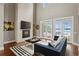 Elegant living room with high ceilings, fireplace, hardwood floors, and expansive windows offering lake views at 1903 Haven Bend, Tampa, FL 33613
