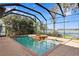 Screened in outdoor pool and hot tub overlooking a serene lake with boat dock at 1903 Haven Bend, Tampa, FL 33613