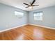 A light and airy bedroom with hardwood floors, two windows, and a ceiling fan at 2446 Belleair Rd, Clearwater, FL 33764