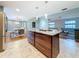 An open concept kitchen boasts an island, stainless steel appliances, and a clear view into the dining and living room at 2446 Belleair Rd, Clearwater, FL 33764