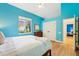 Bright bedroom with cheerful blue walls, wood floors, and ample natural light at 363 Sanctuary Dr, Crystal Beach, FL 34681