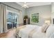 Relaxing bedroom with outdoor access features wood floors, a ceiling fan, and natural light from many windows at 363 Sanctuary Dr, Crystal Beach, FL 34681