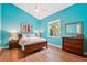 Bright bedroom with colorful walls, a ceiling fan, and a window with green views at 363 Sanctuary Dr, Crystal Beach, FL 34681