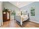 Bright bedroom with warm wood floors, calming colors, and natural light from large windows at 363 Sanctuary Dr, Crystal Beach, FL 34681