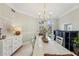 An inviting dining room with a modern chandelier and a view of the beautifully landscaped outdoors at 363 Sanctuary Dr, Crystal Beach, FL 34681