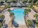 Aerial view of a resort-style community pool with palm trees and lounge chairs at 714 Sugar Camp Way, Brooksville, FL 34604