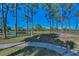 Picturesque landscape featuring mature trees, a tranquil pond, and views of the community at 8005 Bardmoor Pl # 202I, Seminole, FL 33777